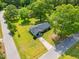 Aerial view of home with well-maintained lawn, long driveway, mature trees, and nearby streets at 492 N Dunn St, Angier, NC 27501