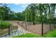 Fenced community dog park surrounded by trees and with various dog park features at 492 N Dunn St, Angier, NC 27501