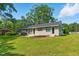 Single-story home featuring brick exterior, dark trim, and a well-manicured lawn on a sunny day at 492 N Dunn St, Angier, NC 27501