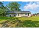 Single-story home featuring brick exterior, dark trim, and a well-manicured lawn on a sunny day at 492 N Dunn St, Angier, NC 27501