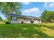 Single-story home featuring brick exterior, dark trim, and a well-manicured lawn on a sunny day at 492 N Dunn St, Angier, NC 27501