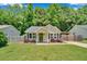 Inviting single-story home with a quaint porch, surrounded by vibrant green lawn and mature trees at 512 Wyndham Dr, Fuquay Varina, NC 27526