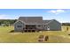 Back of home featuring outdoor deck, covered patio, firepit, and green lawn at 540 Pine Ridge Rd, Zebulon, NC 27597