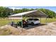 A sturdy metal carport provides ample space for a car and yard equipment at 540 Pine Ridge Rd, Zebulon, NC 27597