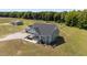 Aerial view of a charming home with gravel driveway and lush green lawn at 540 Pine Ridge Rd, Zebulon, NC 27597