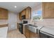 Well-lit kitchen with wooden cabinets, black appliances, stainless steel sink, and white marble countertops at 540 Pine Ridge Rd, Zebulon, NC 27597