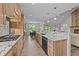 Open kitchen with light wood cabinets, stainless appliances, granite counters and open access to living areas at 540 Pine Ridge Rd, Zebulon, NC 27597