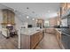 Open kitchen with stainless steel appliances, wooden cabinets, granite counters, and a fireplace in the adjoining living area at 540 Pine Ridge Rd, Zebulon, NC 27597