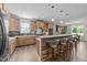 Kitchen with stone island, gray seating, stainless appliances, and light wood cabinets at 540 Pine Ridge Rd, Zebulon, NC 27597