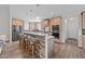 An open kitchen features a large stone-clad island with seating, stainless appliances, and light wood cabinetry at 540 Pine Ridge Rd, Zebulon, NC 27597