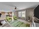 Inviting living room with green accent chairs, large windows, and an open view of the kitchen at 540 Pine Ridge Rd, Zebulon, NC 27597