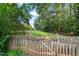 Backyard with a view framed by a wooden fence, lush greenery and a glimpse of open space beyond at 5441 Millrace Trl, Raleigh, NC 27606