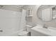 Clean bathroom featuring white sink, round mirror and white tile shower and bathtub at 5441 Millrace Trl, Raleigh, NC 27606
