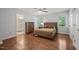 This bedroom features hardwood floors, a ceiling fan, and natural light from large windows at 5441 Millrace Trl, Raleigh, NC 27606