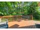 Spacious wooden deck, surrounded by lush greenery, is ideal for relaxing and outdoor entertaining at 5441 Millrace Trl, Raleigh, NC 27606