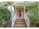 Inviting front porch with brick steps, white railings, and a vibrant red door, offering a warm welcome at 5441 Millrace Trl, Raleigh, NC 27606