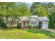 Charming one-story home with green siding, red door, lush lawn, mature trees, and an attached one-car garage at 5441 Millrace Trl, Raleigh, NC 27606