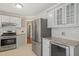 Updated kitchen with stainless steel refrigerator, modern appliances, and stylish gray cabinets at 5441 Millrace Trl, Raleigh, NC 27606