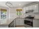 Well-lit kitchen with stainless steel appliances, white cabinetry, granite countertops, and stylish hardware at 5441 Millrace Trl, Raleigh, NC 27606