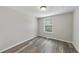 Bedroom featuring neutral walls, wood-look flooring, and a window offering natural light at 5529 Wood Pond Ct, Raleigh, NC 27610