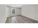 Bedroom with neutral walls, wood-look floors, a window letting in light, and baseboard trim at 5529 Wood Pond Ct, Raleigh, NC 27610