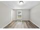 Bedroom featuring neutral walls, wood-look flooring, and a window offering natural light at 5529 Wood Pond Ct, Raleigh, NC 27610
