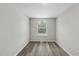 This bedroom features neutral walls, wood-look flooring, and a window offering natural light at 5529 Wood Pond Ct, Raleigh, NC 27610