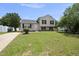 Traditional home with a manicured lawn, a dark roof, and classic beige siding at 5529 Wood Pond Ct, Raleigh, NC 27610