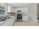 Bright kitchen features white cabinets, stainless steel appliances, and tile flooring at 5529 Wood Pond Ct, Raleigh, NC 27610