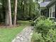 Stone pathway leading up to the home, featuring lush greenery and mature trees for a serene setting at 5816 Henner Pl, Durham, NC 27713