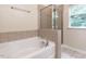 Tranquil bathroom featuring a soaking tub, separate glass shower, and natural light from the window at 6206 Braidwood Court Ct, Raleigh, NC 27612