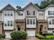 Charming townhome exteriors boast stone accents, neutral siding, attached garages, and manicured shrubs at 6206 Braidwood Court Ct, Raleigh, NC 27612