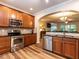 Well-equipped kitchen featuring stainless steel appliances, granite countertops, and an archway to the living room at 6206 Braidwood Court Ct, Raleigh, NC 27612