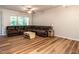 Open-concept living room features wood flooring, a ceiling fan, and large windows that fill the room with light at 6206 Braidwood Court Ct, Raleigh, NC 27612