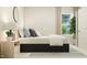 Calm bedroom featuring a bed with decorative pillows, a nightstand, and a view of the outdoors through a window at 708 Swim Cave Ln, Wendell, NC 27591