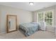 Bright bedroom featuring a window, white metal bed frame, full-length mirror and carpeted floors at 712 Brittley Way, Apex, NC 27502