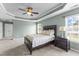 Primary bedroom with an attached sitting room, a ceiling fan, and two large windows at 712 Brittley Way, Apex, NC 27502