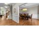 Open-concept view to dining room with hardwood floors, wainscoting, and transitional lighting at 712 Brittley Way, Apex, NC 27502