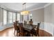 Formal dining room showcasing stylish lighting, hardwood floors, and elegant wainscoting at 712 Brittley Way, Apex, NC 27502
