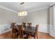 Spacious dining room with classic lighting, hardwood flooring, and beautiful wainscoting details at 712 Brittley Way, Apex, NC 27502