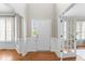 Bright foyer with white wainscoting, hardwood floors, and an open doorway to the side yard at 712 Brittley Way, Apex, NC 27502