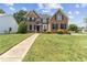 Beautifully maintained front yard and charming brick house with mature landscaping at 712 Brittley Way, Apex, NC 27502