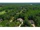 Beautiful home nestled among trees, with an aerial view showcasing the surrounding neighborhood and landscape at 7552 Hasentree Club Dr, Wake Forest, NC 27587