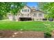 Expansive backyard with a deck, lush lawn, mature trees, and a hot tub for outdoor entertaining at 7552 Hasentree Club Dr, Wake Forest, NC 27587