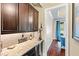Elegant bar area with wine storage, granite counters, and dark wood cabinets at 7552 Hasentree Club Dr, Wake Forest, NC 27587