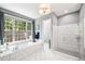 A spa-like bathroom with a soaking tub, a walk-in shower, and natural light at 7552 Hasentree Club Dr, Wake Forest, NC 27587