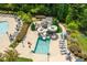 Aerial view of a resort-style community pool featuring a slide, seating, and lush landscaping at 7552 Hasentree Club Dr, Wake Forest, NC 27587