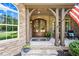 Inviting stone front porch with double doors, decorative wreaths, and elegant decor at 7552 Hasentree Club Dr, Wake Forest, NC 27587