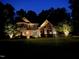 Beautiful home at night featuring elegant outdoor lighting and manicured landscape at 7552 Hasentree Club Dr, Wake Forest, NC 27587