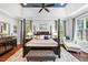 Bright main bedroom with four-poster bed, dark wood floors and an elegant sitting area at 7552 Hasentree Club Dr, Wake Forest, NC 27587
